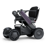 WHILL Model C2 power wheelchair with a plum arm cover, three-quarter view