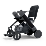WHILL Model F folding power wheelchair with a black arm cover, three-quarter view