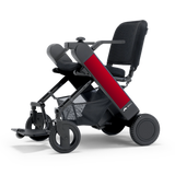 WHILL Model F folding power wheelchair with a red arm cover, three-quarter view