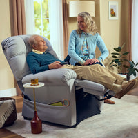A man reclined in the Perfect Sleep Chair with his feet raised, talking with a woman beside him