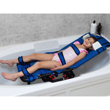 A girl reclined in an Anchor bath chair in the tub, with the positioning straps fastened