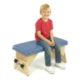 A boy sitting upright on an Axis bench