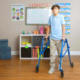 A boy walking with a blue Klip behind him in a classroom