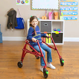 A girl walking in a classroom with a red Klip with seat