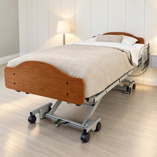 Invacare CS600 hi-low bed made up in a bedroom, seen from the foot end, wood-look head and foot panels and a quarter length rail at the head