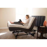 A woman reading on a Flexabed Hi-Low SL with the head section raised