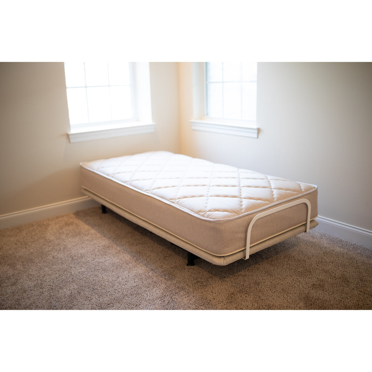 A twin Flexabed Value-Flex adjustable bed with its innerspring mattress, shown flat in a bedroom