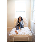 A woman sitting up on a Flexabed Value-Flex with the head section raised, seen from the foot of the bed