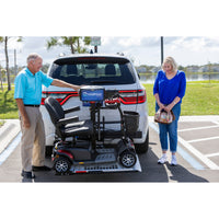 A couple loading a scooter onto a Harmar AL100 lift behind their vehicle