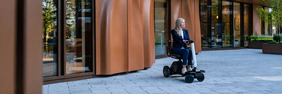 A woman riding a four-wheel mobility scooter outdoors