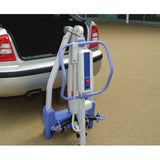 The folded Hoyer Advance standing beside an open car trunk