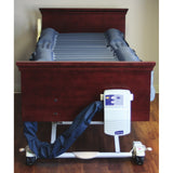 A Joerns DermaFloat LAL mattress on a bed, with its control unit hung on the foot panel