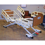 A Joerns EasyCare bed in a room, shown with optional half length assist devices and panels