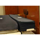 A Joerns foam bolster at the foot of a mattress on a bed