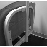 The Joerns trapeze adapter mounted at the head of a bed frame, with the trapeze bar post standing in it