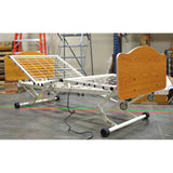 A Joerns WeCare frame with wood grain panels and its head section raised