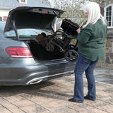 A Journey Air Elite Max being loaded folded into the trunk of a car
