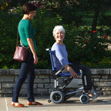A woman driving a Journey Zinger outdoors alongside a friend walking