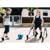 A boy walking outdoors in the MyWay+, kicking a ball