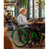 A woman reading in a cafe, seated in a Helio A6 in Monster Green