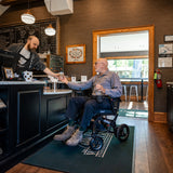 A man using the Pride Jazzy Ultra Light power wheelchair at a cafe counter