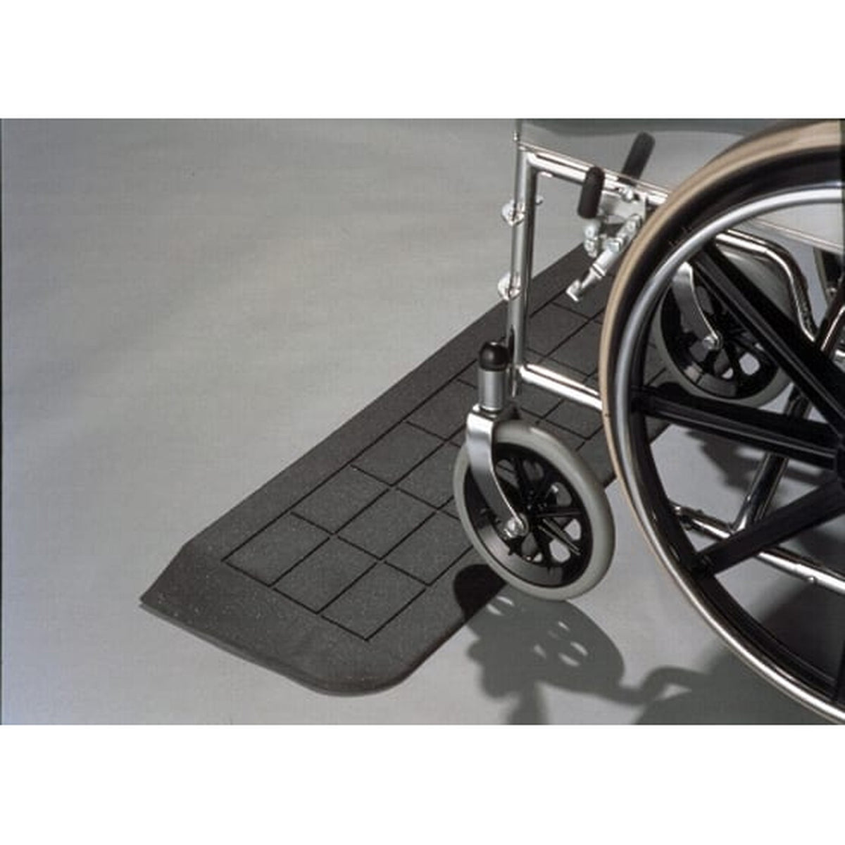 PVI rubber threshold ramp at a doorway with a wheelchair wheel rolling onto it