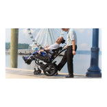 Caregiver tilting a rider in the Quickie IRIS outdoors