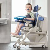 A boy on a Flamingo Curo compact frame over a toilet, with a tray and a foot support