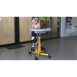 A girl smiling in a yellow Gazelle PS size 1 with a plastic tray