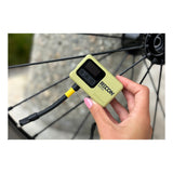 VIAIR Recon Mini air compressor held in one hand, with its hose attached