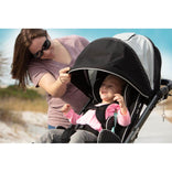 A caregiver adjusting the Zippie Voyage canopy over a smiling child