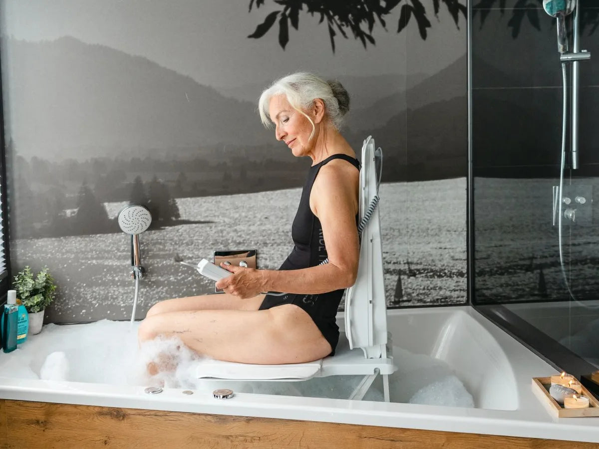 A woman sitting on a bath lift seat in a bathtub