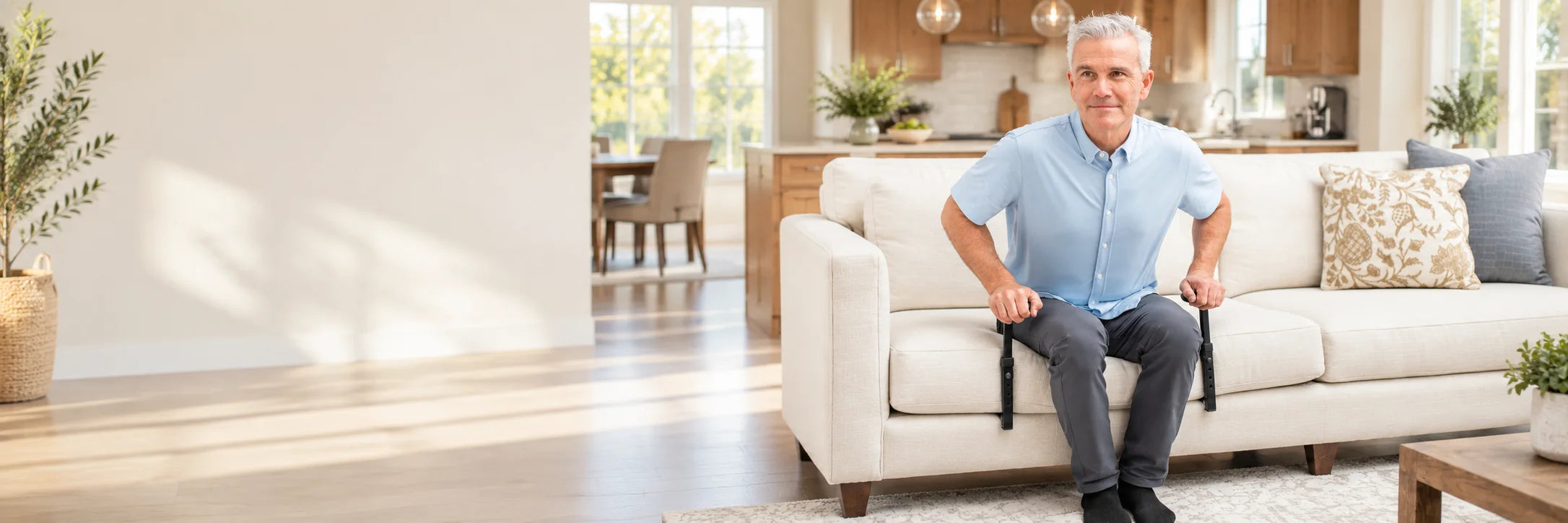 A man pushing up from his sofa on a pair of standing aid handles