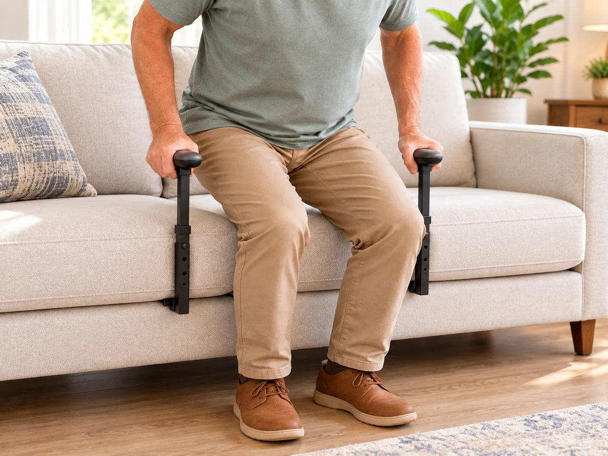 A man gripping two standing aid handles as he rises from a sofa