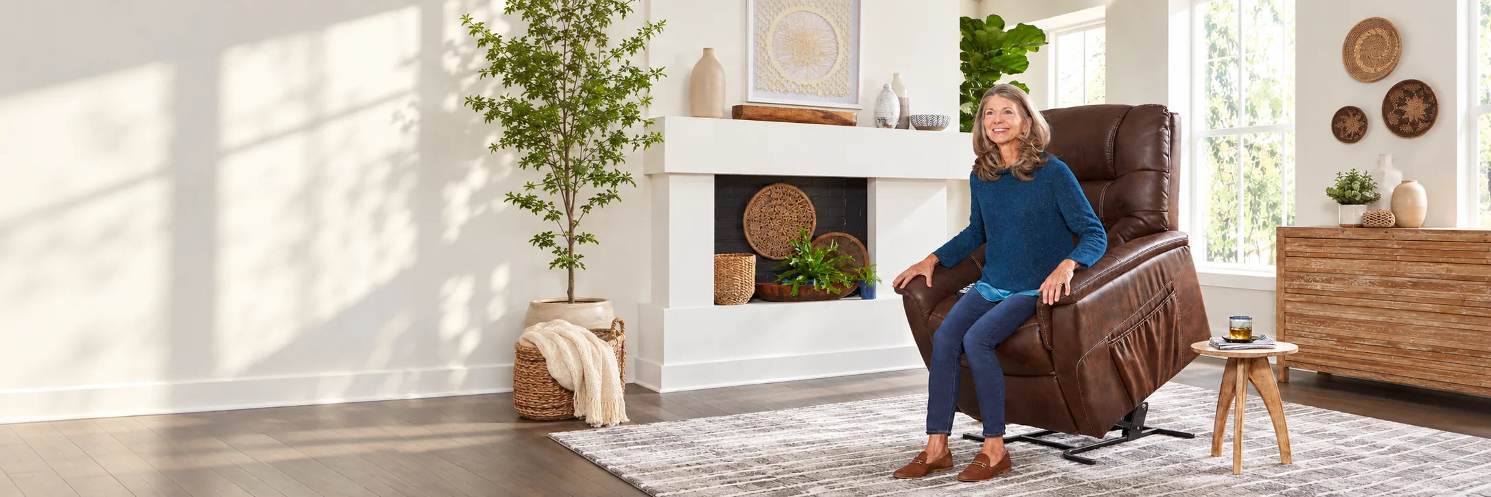 A smiling woman rising from a brown lift chair in a bright living room