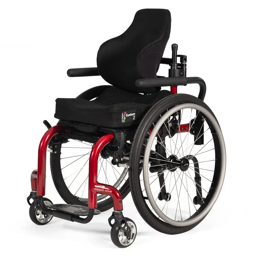 A red-framed pediatric manual wheelchair with a padded back