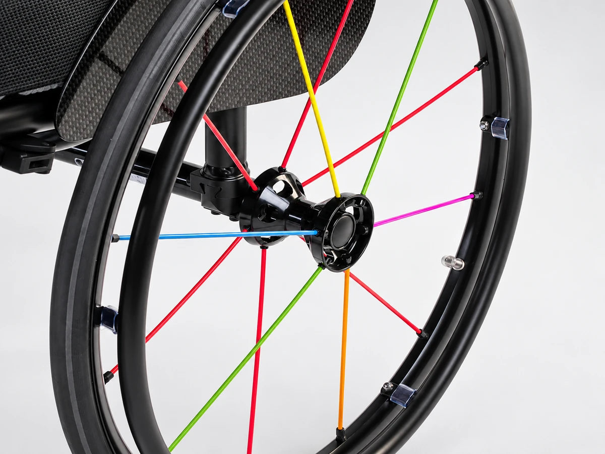 A wheelchair rear wheel with a black rim, a black handrim and spokes in several colors