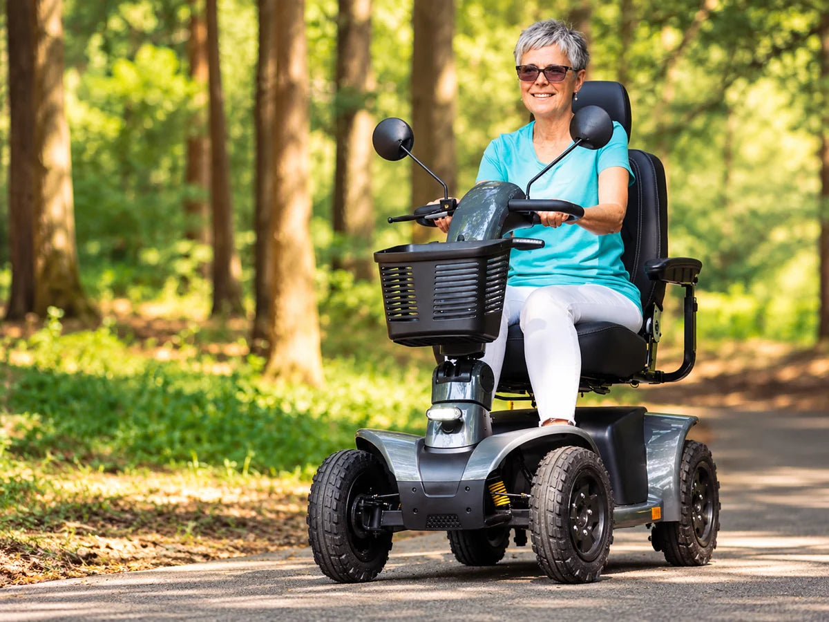 A woman riding a four-wheel mobility scooter on a wooded path