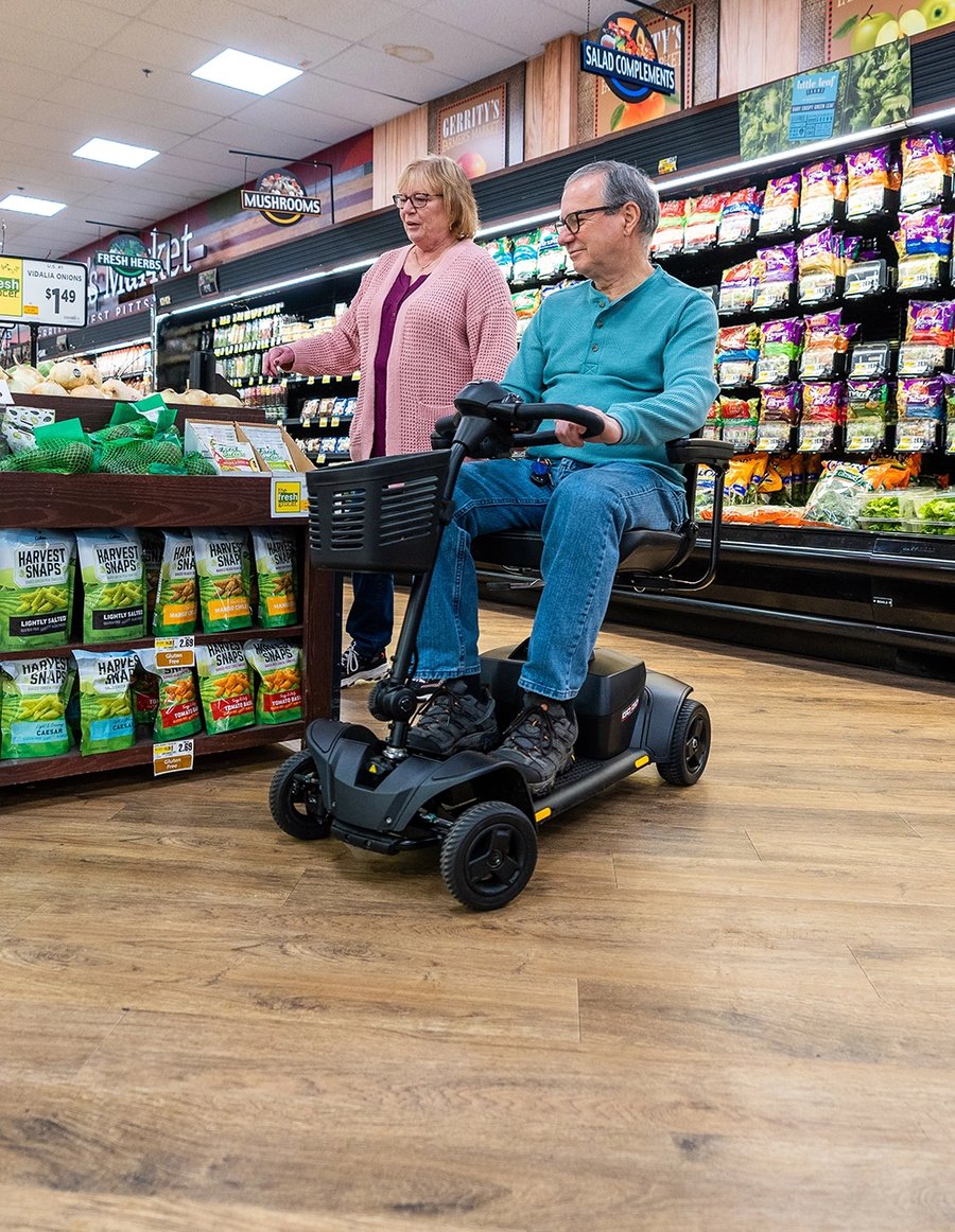 A man on a mobility scooter shopping with his wife