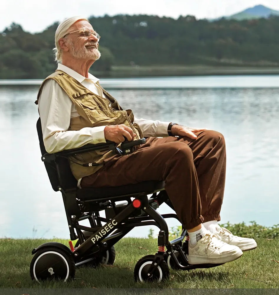 A man outdoors by a lake using a lightweight folding power wheelchair