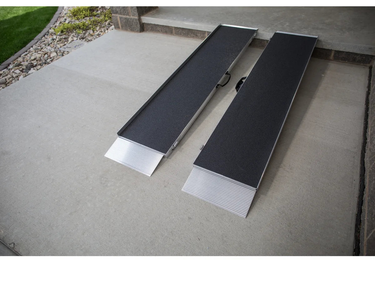 Two folded suitcase ramps set against a low step