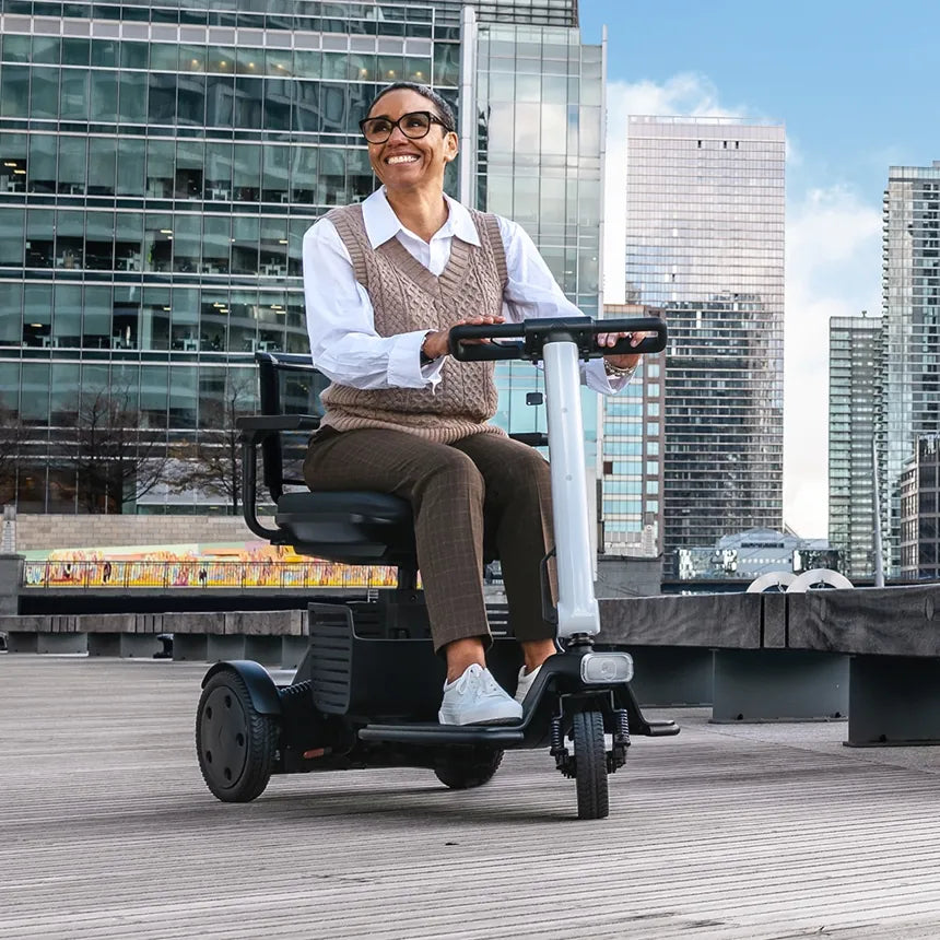 A woman riding a three-wheel mobility scooter on a city walkway