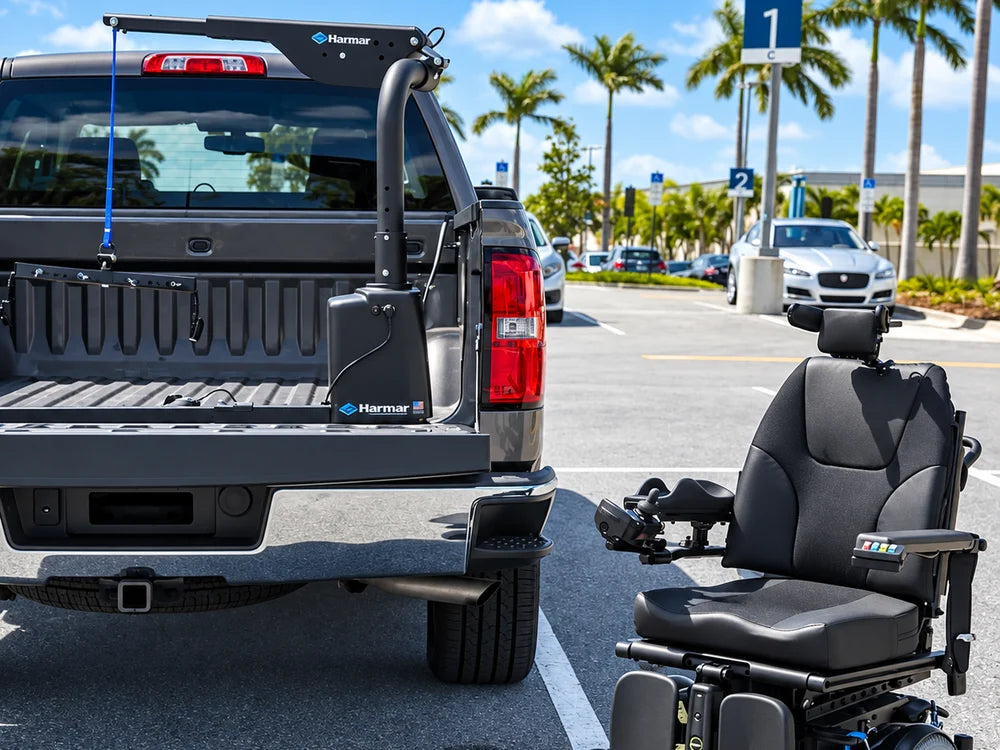 A pickup truck with a bed-mounted lift, a power wheelchair parked beside it
