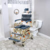 TubBuddy Tilt shower and commode chair with padded seat, adjustable footrests, corrosion-resistant aluminum frame, and tilt-in-space functionality for enhanced comfort.