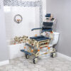 TubBuddy Tilt shower and commode chair with padded seat, adjustable footrests, corrosion-resistant aluminum frame, and tilt-in-space functionality for enhanced comfort.