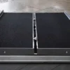 Harmar Single Fold Ramp folded in half with a carrying handle, placed on a curb, showing its lightweight and portable design.