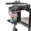 Cup holder attached under the armrest padding of a Pride Mobility scooter, securely holding a beverage for easy access during travel.