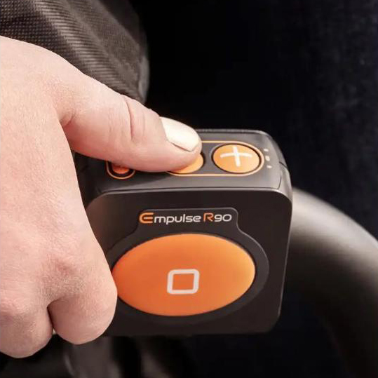 Empulse R90 Power Assist Device attached to a wheelchair, providing lightweight mobility support with a range of up to 9 miles.