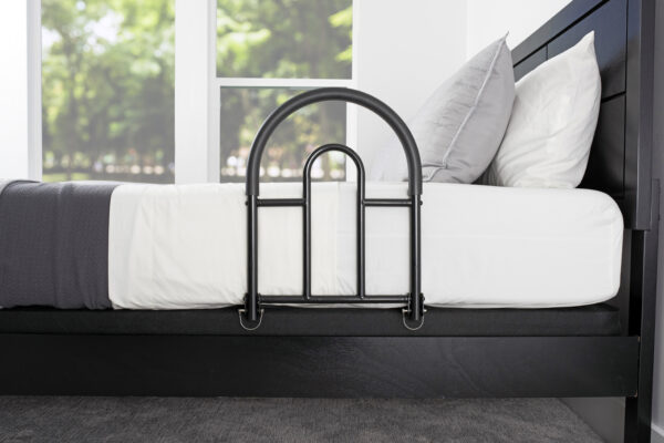 Stander Bed Rail Advantage Traveler, shown folded on a bed, providing secure support for bed transfers at home or on-the-go.