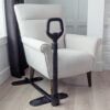 Stander Couch Cane beside a couch, showing the adjustable handle and organizer pouch for convenient support.